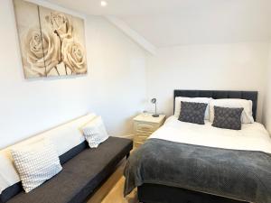 um quarto com uma cama e um sofá em Charming 3-Bed Home Minutes From City Centre em Nottingham