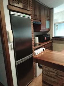 uma cozinha com um frigorífico preto e armários de madeira em El Celemín em Benalup Casas Viejas