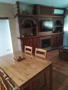 uma sala de estar com uma mesa de madeira e uma lareira em El Celemín em Benalup Casas Viejas