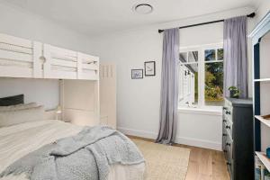 een witte slaapkamer met een bed en een raam bij Birdsong, Kangaroo Valley in Barrengarry