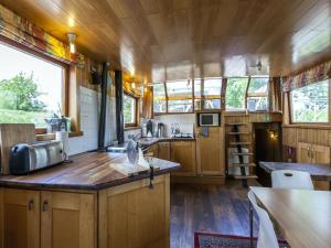 a kitchen with wooden cabinets and wooden floors at Cozy Boat in Merkem near Lake in Drie Grachten