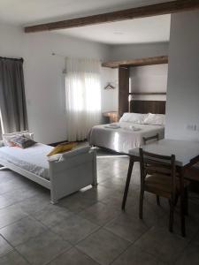 a bedroom with two beds and a table and a chair at La Higuera con Parking A in Azul