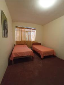 洛維托斯區的住宿－Casa hospedaje cora，带窗户的客房内的两张床