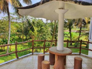 une véranda avec une table, des arbres et une clôture dans l'établissement "GreenHeart" Eco Villa - Inspire the Nature with Fresh Air- Specious Top Floor with Balcony views', à Maharagama