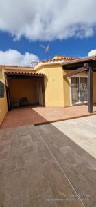 a yellow house with a patio in front of it at Casa Nicole in Caleta De Fuste