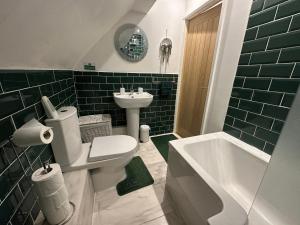 a bathroom with a toilet and a sink and a tub at Sherwood Forest in Nottingham