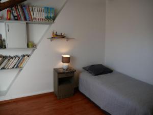a bedroom with a bed and a table with a lamp at Appartement charmant, 3 chambres, centre de Meung-sur-Loire, près de la Loire et du château - FR-1-590-246 in Meung-sur-Loire