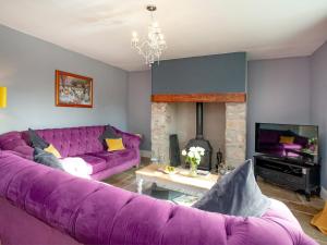 una sala de estar con muebles morados y un sofá púrpura. en Uk45542-the Farm House, en Sticklepath