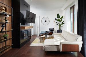 a living room with a white couch and a fireplace at 21st Century Zlatibor Residence, Spa & Wellness by Adora in Zlatibor