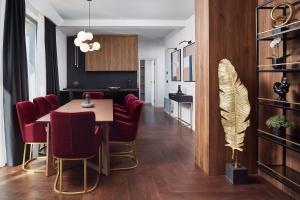una sala da pranzo con tavolo e sedie rosse di 21st Century Zlatibor Residence, Spa & Wellness by Adora a Zlatibor