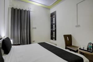 um quarto com uma cama, uma secretária e uma cadeira em Thirty Inns em Noida