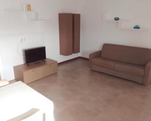 ein Wohnzimmer mit einem Sofa und einem TV in der Unterkunft Homeity Property in Mindelo
