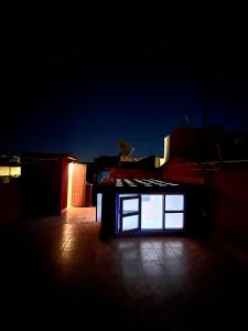 Dar mi Yamna في الرباط: غرفة مظلمة مع نافذة على مبنى في الليل