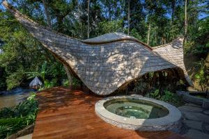 eine Hängematte mit Pool inmitten eines Waldes in der Unterkunft Permata Ayung Private Estate in Ubud