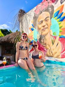 un gruppo di tre donne sedute in piscina di Hostal Guacamayas a Valladolid
