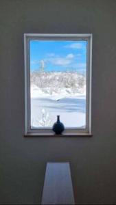 una ventana con un jarrón sentado en una habitación en Furano Hidden Hill【FHH】, en Kami-furano