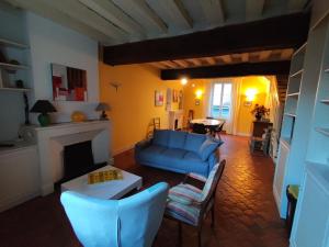a living room with a blue couch and a fireplace at Appartement charmant, 3 chambres, centre de Meung-sur-Loire, près de la Loire et du château - FR-1-590-246 in Meung-sur-Loire