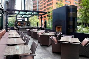 a restaurant with tables and chairs and a fireplace at The Westin Calgary in Calgary