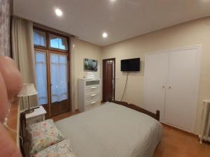 um quarto com uma cama, uma cómoda e uma televisão em Uría 25 rooms em Oviedo