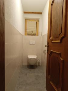 a small bathroom with a toilet and a window at Kathrins Ferienwohnung in Breitenbach am Inn