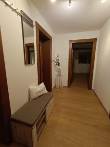 a room with a bench and a mirror and a hallway at Kathrins Ferienwohnung in Breitenbach am Inn