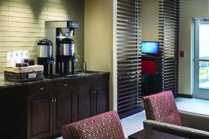 a coffee bar with two chairs and a coffee maker at AeroStay in Sioux Falls