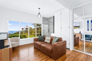斯坦威尔公园Romantic Ocean View Studio at Stanwell Tops的带沙发和大窗户的客厅