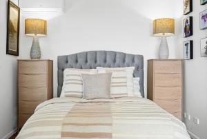 斯坦威尔公园Romantic Ocean View Studio at Stanwell Tops的一间卧室，配有一张床、两个床头柜和两盏灯