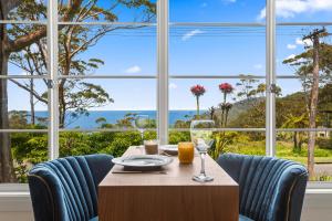 斯坦威尔公园Romantic Ocean View Studio at Stanwell Tops的一间有桌椅和大窗户的餐厅