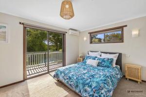 1 dormitorio con 1 cama y balcón en Packed to the Rafters - Room for Everyone, en Wonthaggi
