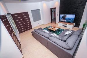 a living room with a couch and a flat screen tv at RESIDENCE MH SERVICES Cotonou in Cotonou