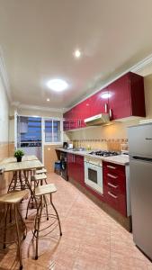 a kitchen with red cabinets and a table and chairs at RABAT APPARTEMENT A 2 Minutes DE LA GARE DE TRAIN AGDAL in Rabat