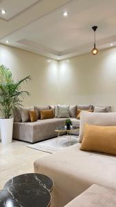 a living room with a couch and a table at SUITOUISS - Agdal 1 - Appartement à 2 minutes de la gare de train TGV Rabat in Rabat