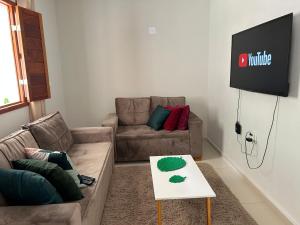 sala de estar con sofá y TV en Agradável Casa de Campo, recém construída., en Divisa