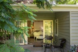 a patio with a table and chairs on a house at River cottage in Tilba Tilba