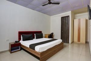 a bedroom with a large bed and a ceiling at Omi Inn Manesar in Manesar