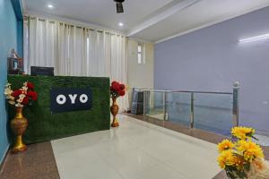 a lobby with a ovy sign on a green wall at Omi Inn Manesar in Manesar