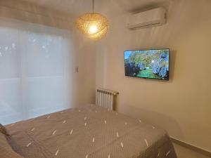 a bedroom with a bed and a tv on the wall at Punta Tejada in Monte Hermoso