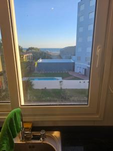 a window above a sink with a view of a building at Punta Tejada in Monte Hermoso