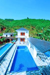 una imagen de una piscina frente a una casa en The Hillside Homes en Phong Nha