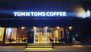 Un cartello sulla parte anteriore di una città Tom Tom Tom Tom beve caffè. di THE KOA Hotel & Spa a Angeles