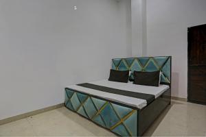 un letto in una camera bianca con riconoscimento di SPOT ON Shree Sarveshwar Party Lawn And Hotel a Kānpur