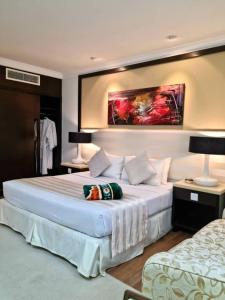 a hotel room with a large bed and two lamps at The Jerai Hotel Alor Star in Alor Setar