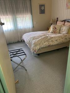 a bedroom with a bed and a chair in it at Butlers Guesthouse in Birregurra