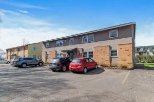 two cars parked in a parking lot in front of a building at Tranquil 2BR Apt Mpls - 8073 Apt 1 in Spring Lake Park