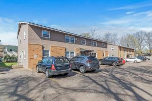 two cars parked in a parking lot in front of a building at Tranquil 2BR Apt Mpls - 8073 Apt 1 in Spring Lake Park