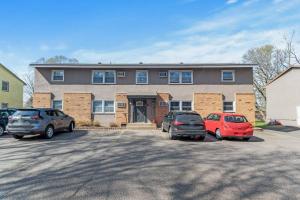 two cars parked in a parking lot in front of a house at Tranquil 2BR Apt Mpls - 8073 Apt 1 in Spring Lake Park