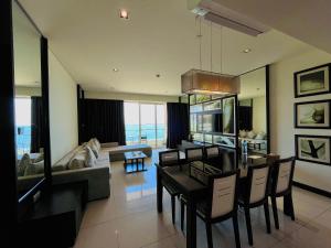 a dining room and living room with a table and chairs at The Sea Luxury Nha Trang Apartment in Nha Trang