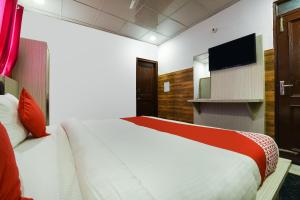 1 dormitorio con 1 cama grande y TV en Collection O 13772 hotel krishna, en Noida