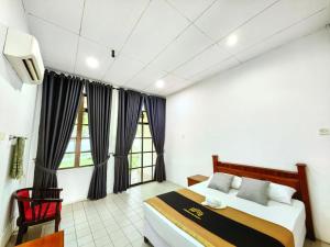 a bedroom with a bed and a tv in it at Deluxe Room in Pendang